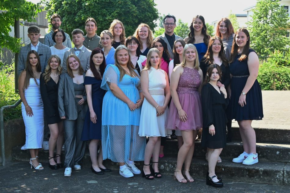 SchülerInnen und Klassenlehrer freuen sich über ihr bestandenes Abitur am Beruflichen Gymnasium für Erziehungswissenschaften des Reckenberg Berufskollegs.